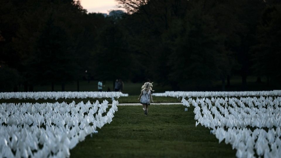 Young girl running through a field of white flags