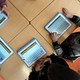 Children sit a table using tablet computers