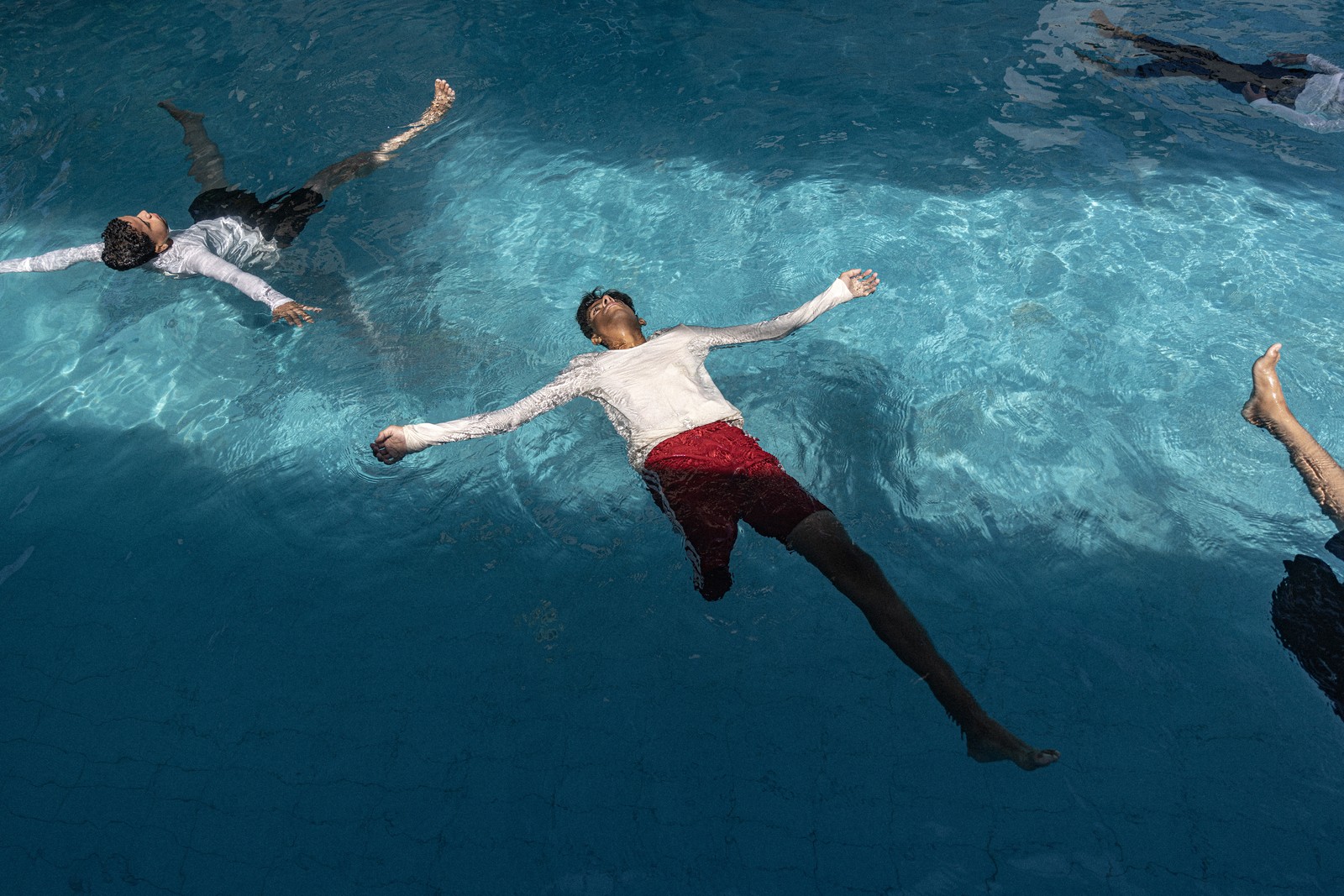 Several children float in a swimming pool during a training session.