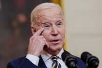 President Joe Biden speaks in front of microphones.