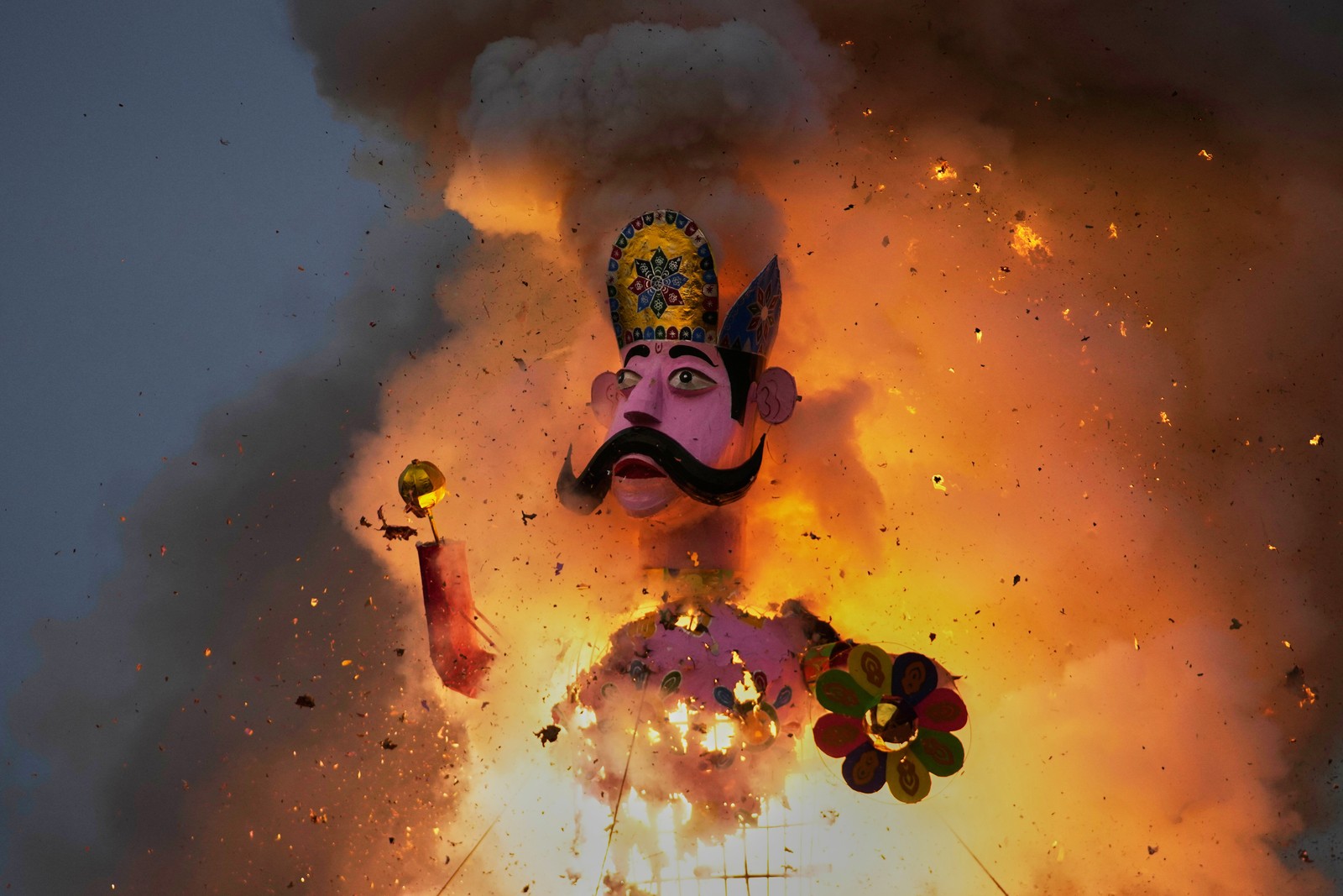 An effigy of a mythical demon goes up in flames during a festival.