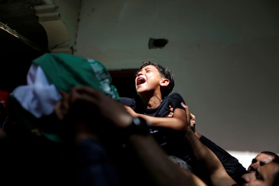 A boy cries among others during a funeral.
