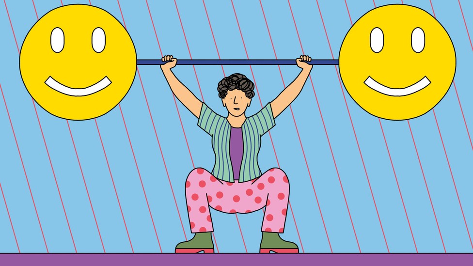 A person lifts a large barbell with smiley faces on either end.