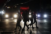 People cross a road during a power outage in the Crimean city of Simferopol on November 24, 2015.