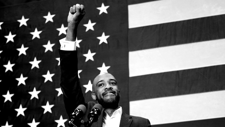 Picture of Mandela Barnes raising fist in front of American flag.