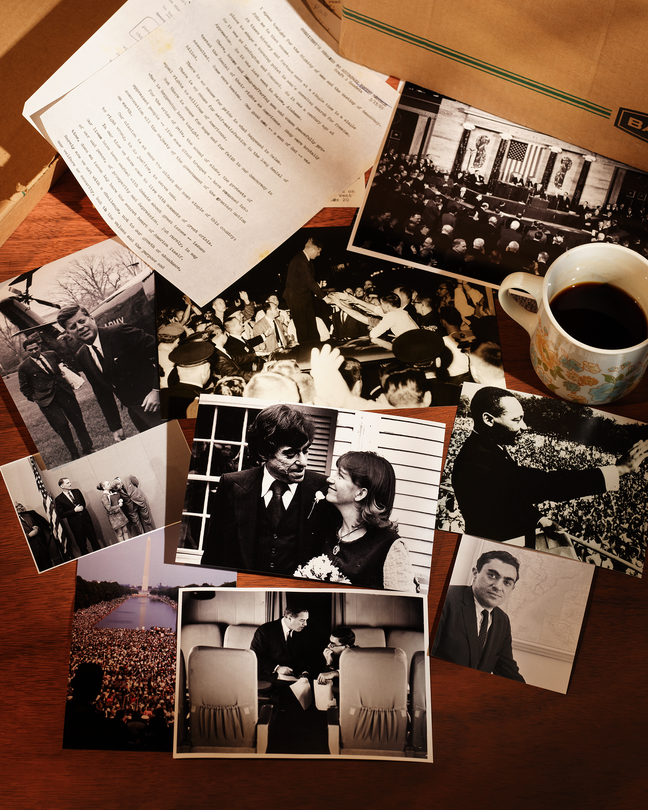Multiple old pictures and documents next to a brown box and a cup of coffee