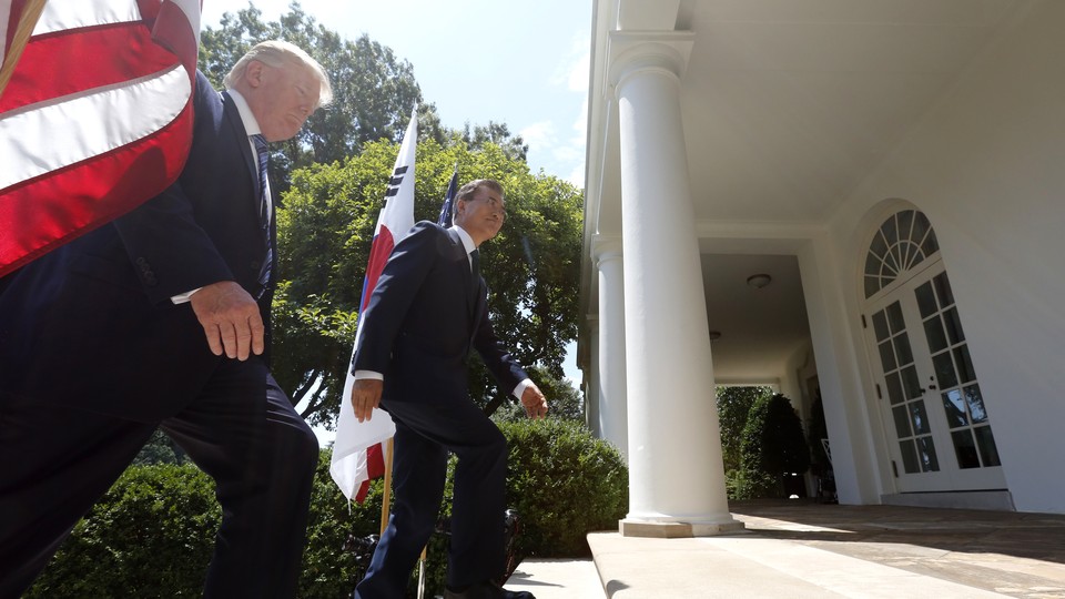 President Trump and South Korean President Moon Jae-in walk up the stairs of the rose garden with a U.S. and South Korean flag behind them.