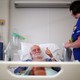 A man giving the "thumbs-up" sign in a British hospital bed
