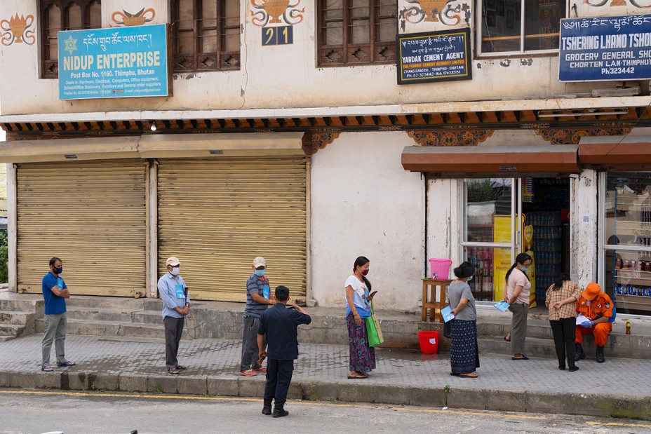 Local residents maintain social distancing as they stand in a queue to buy groceries outside a store during a nationwide lockdown imposed as a preventive measure against the spread of the COVID-19 coronavirus at Thimphu in Bhutan, on August 20, 2020. 