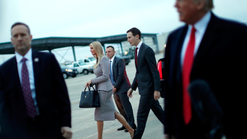 Ivanka Trump and Jared Kushner pass behind Donald Trump.