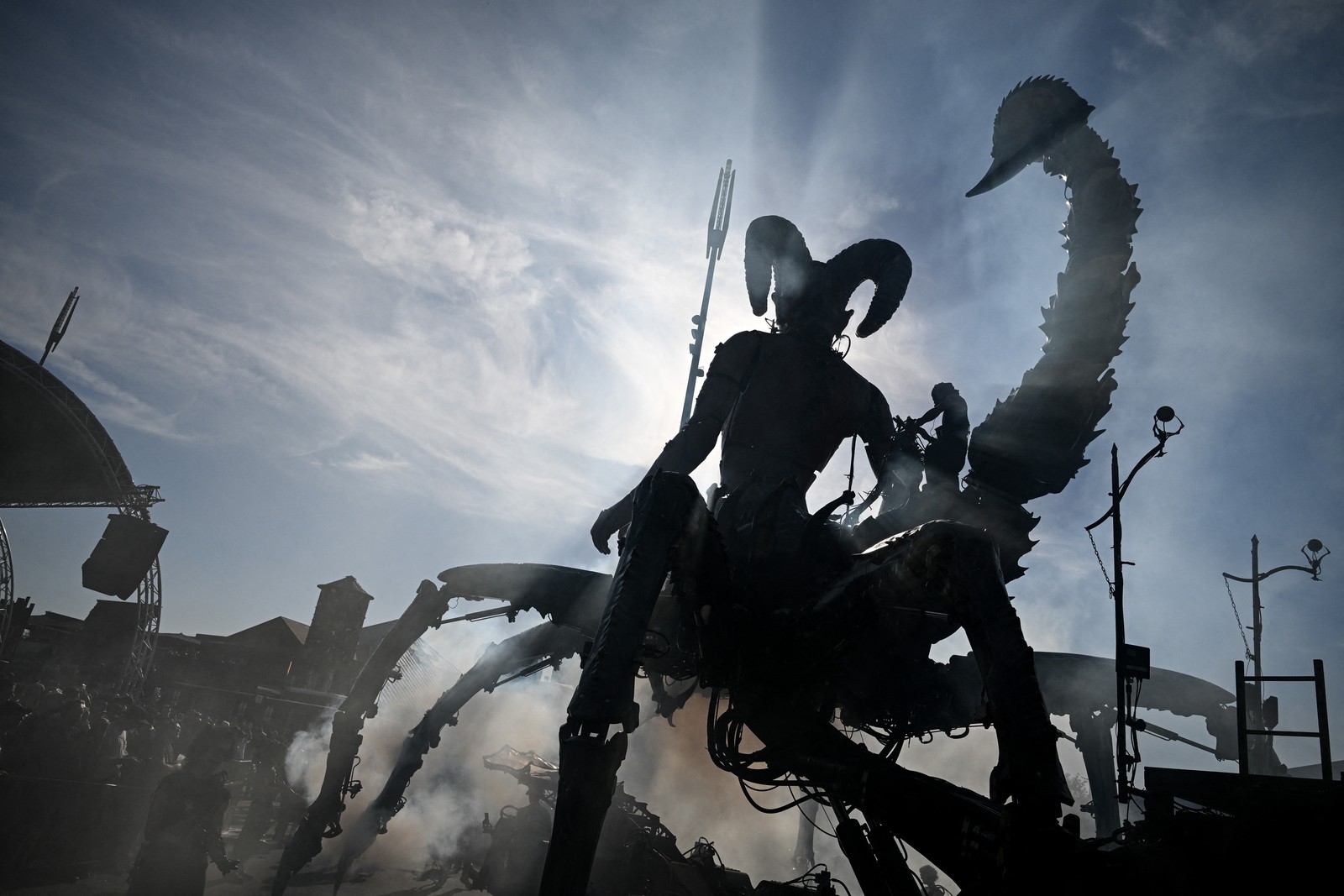 A large mechanical puppet, shaped like a demonic scorpion with a woman's torso, seen at a music festival