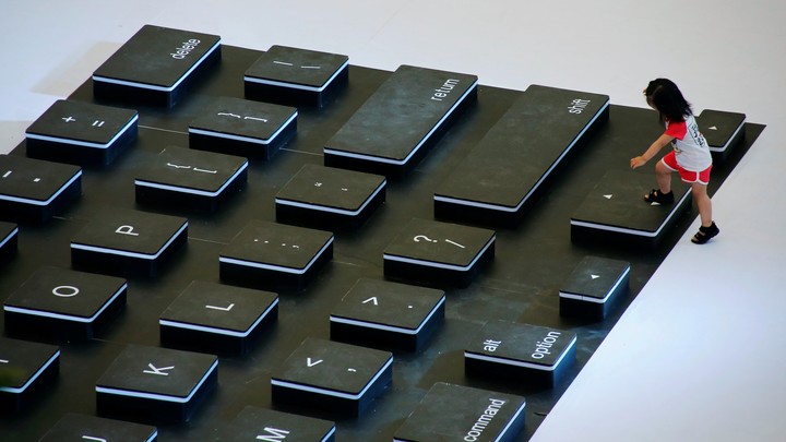 A child climbs onto a giant mockup laptop keyboard