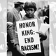 woman holding sign "Honor King: End Racism!"