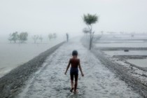 A child walking on a path near water.