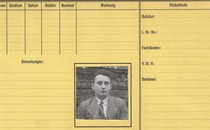 A yellow card with columns and rows titled in German, and a black and white image of a young man in a suit pasted in a square in the center