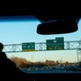Highway signs for I-95 and I-295 at the exit for New Brunswick in New Jersey, viewed through a car windshield