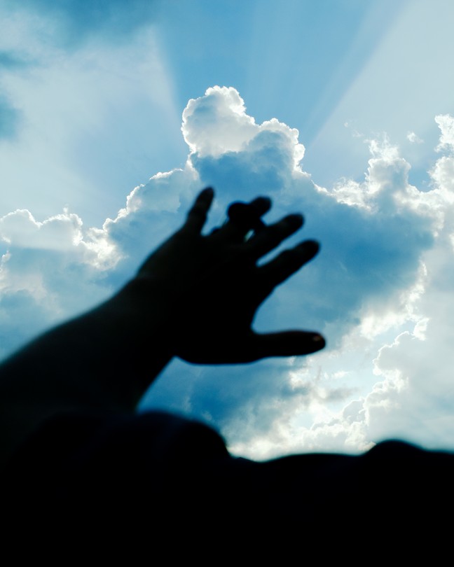 A hand held up against a sky