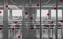 An illustration of a black-and-white conference room overlaid with red dots