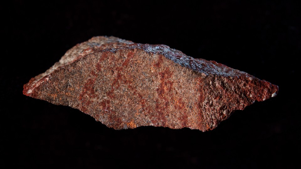 Blombos Cave drawing with ochre crayon on silcrete stone