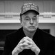 A photo of Elon Musk sitting in a Cabinet meeting, wearing a hat that reads: "Trump was right about everything."