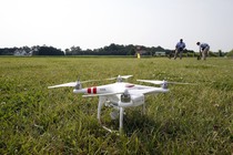 A DJI Phantom 2 drone sits on grass.