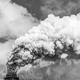 Fotografía en blanco y negro de humo saliendo de una chimenea.