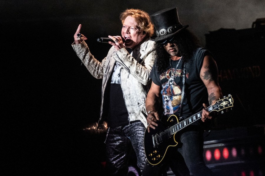 Two members of the rock band Guns N' Roses perform onstage.