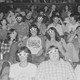 Black and white photograph of movie-goers wearing 3D glasses in a theater at a showing.
