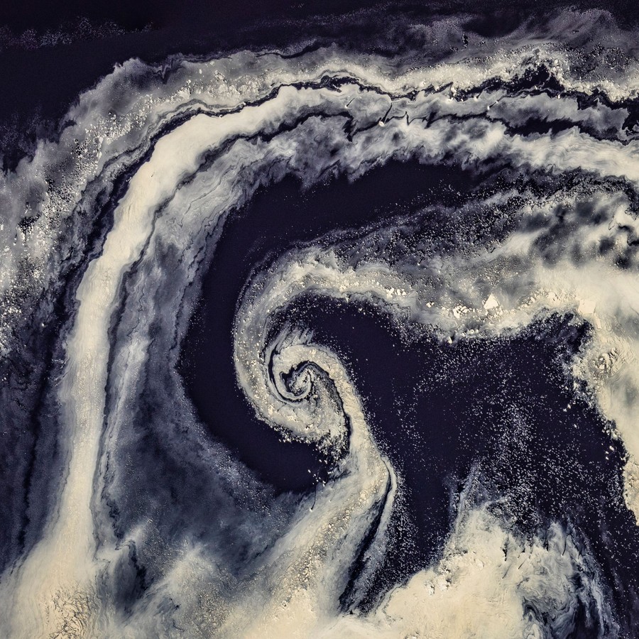 A spiral shape resembling a hurricane, made of stripes of white and black material.