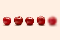 Five apples in a line, but the furthest one on the right is blurry