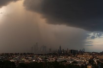 Dark rain clouds hover over the New York City skyline.