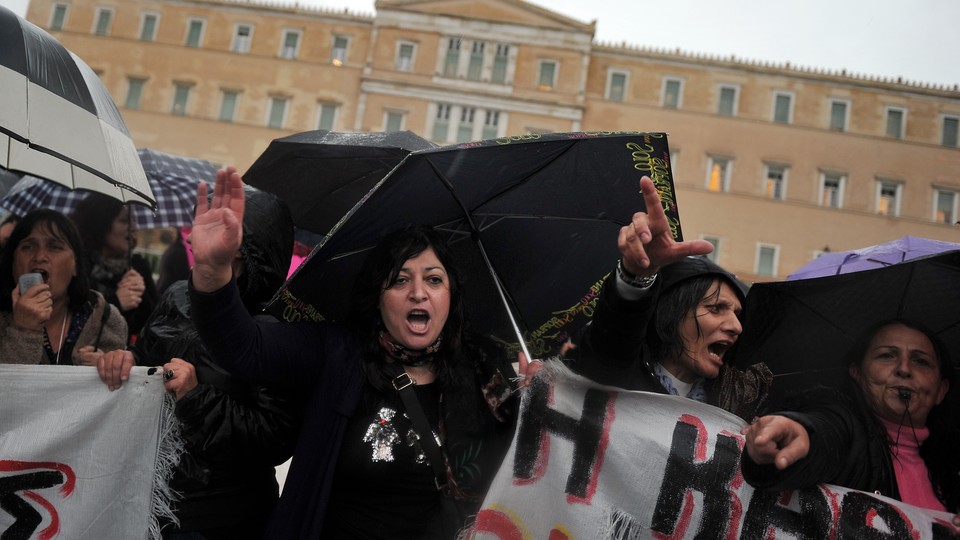 Suspended Finance Ministry janitors protest outside the Greek Parliament in 2013.