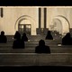 silhouettes of figures sitting in pews
