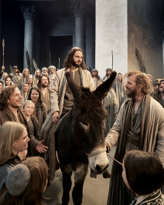 Jesus in passion play riding on a donkey.