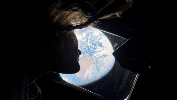 Christina Koch's braids float as she stares at the Earth from Artemis II's spacecraft