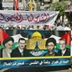 Protestors hold up a banner picturing late Ayatollah Ruhollah Khomeini, Syrian President Bashar al-Assad and Iranian Supreme Leader Ali Khameni and late Syrian Presidnet Hafez al-Assad.