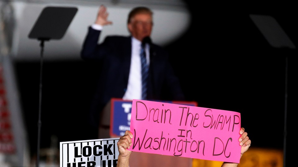 A man holds a "Drain the Swamp in Washington, D.C.," sign at a campaign event for Donald Trump