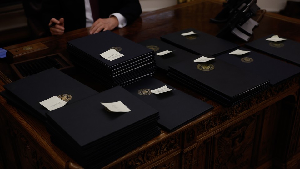 Multiple piles of executive orders on Donald Trump's desk