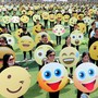 A crowd of people holding up signs with different emoji faces