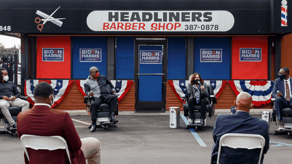 Kamala Harris speaks as part of a panel outside a barbershop.