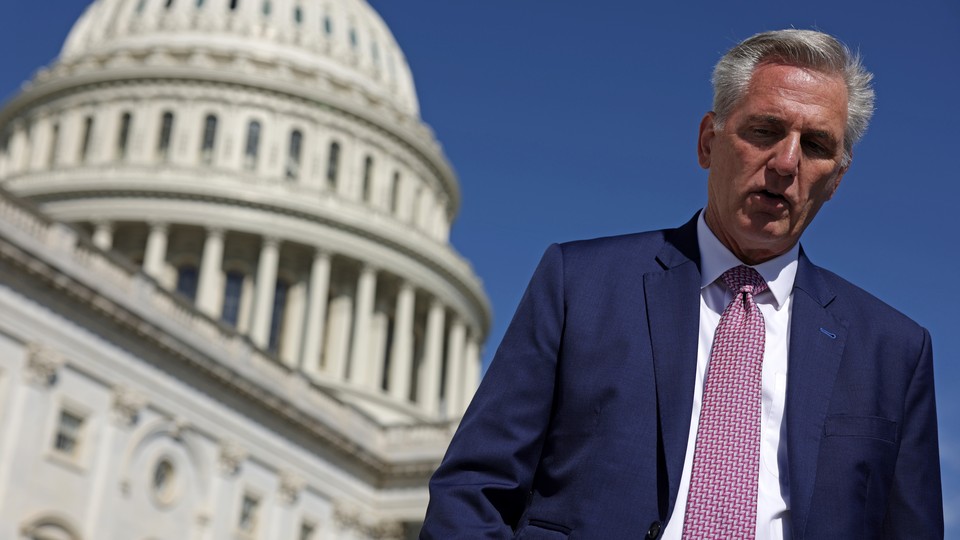U.S. House Minority Leader Kevin McCarthy walking toward the camera, with the U.S. Capitol behind him