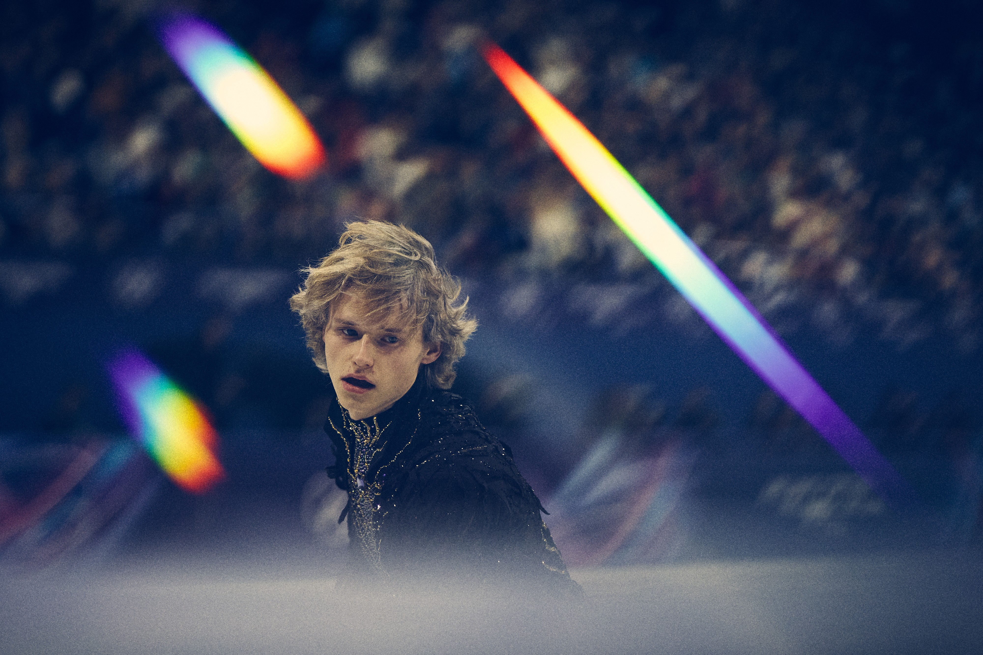 A figure skater, seen in a filtered image with several rainbow streaks