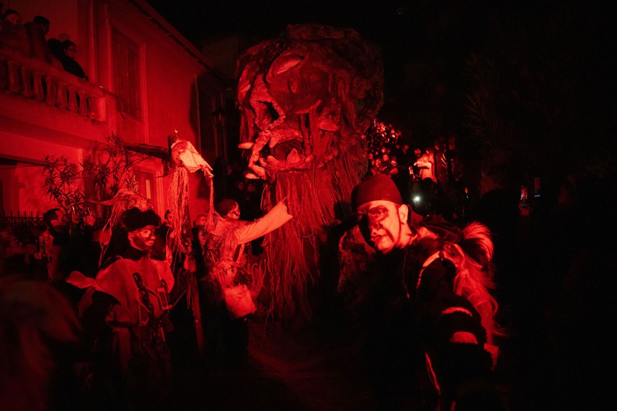 People in traditional costumes march in a night parade.