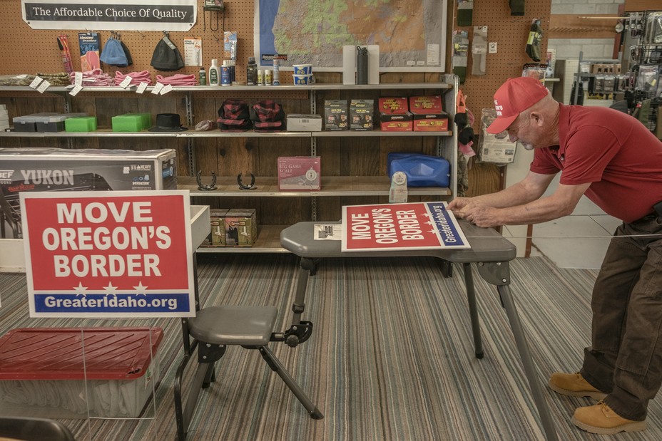 Mike McCarter, the head of Move Oregon's Border and Citizens for Greater Idaho, prepares yard signs ahead of a Move Oregon's Border meeting at HC Sporting Goods in Hines, Oregon, on Saturday, October 16. 
