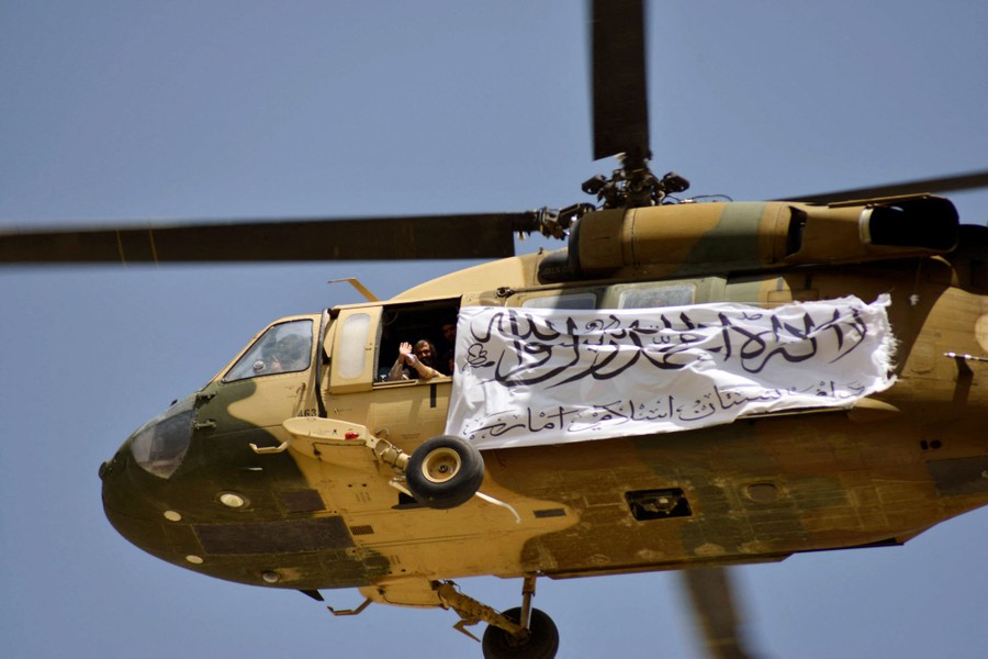 A helicopter displaying a Taliban flag flies above Kandahar.