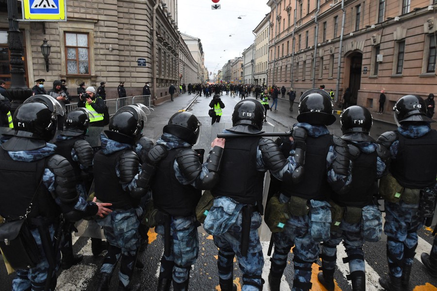 Riot police officers block a street in a Russian city.