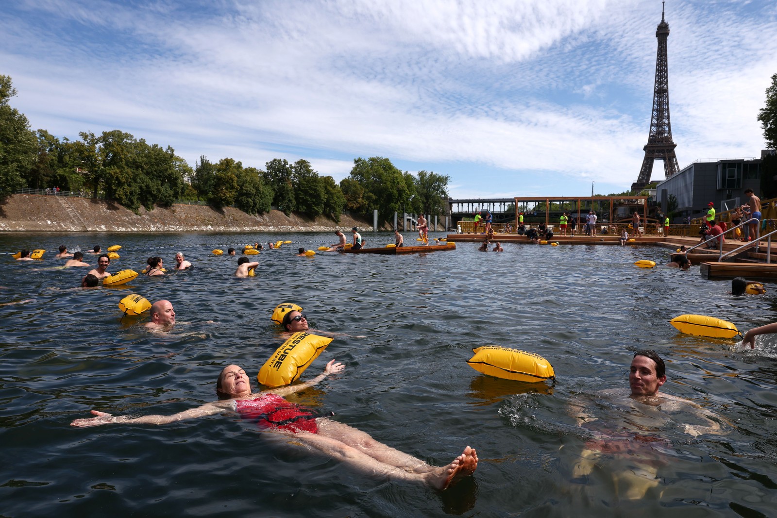 People swim in a river in Paris, near the Eiffel Tower.
