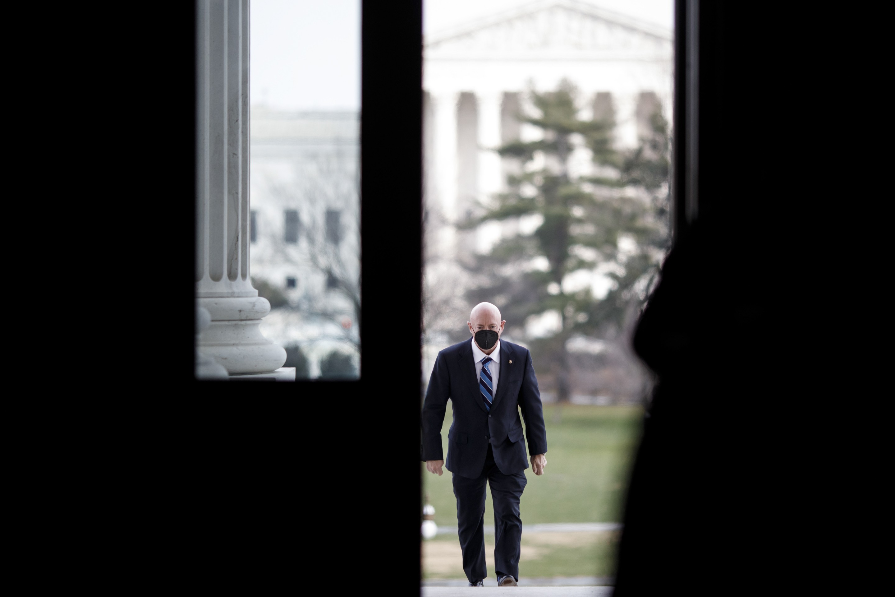 a man walks in DC with a suit on and a mask on his face