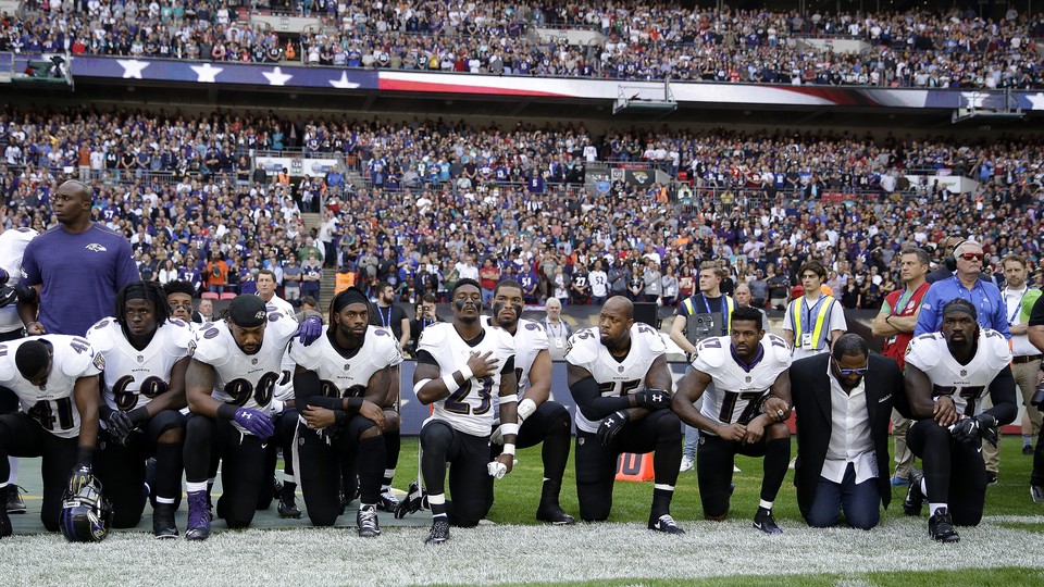 Baltimore Ravens players, including former player Ray Lewis, kneel during the playing of the U.S. national anthem before an NFL football game against the Jacksonville Jaguars at Wembley Stadium in London, Sept. 24.