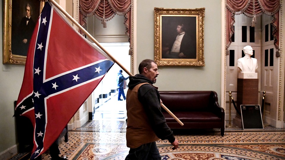 A Trump supporter carrying a Confederate flag through the U.S. Capitol.